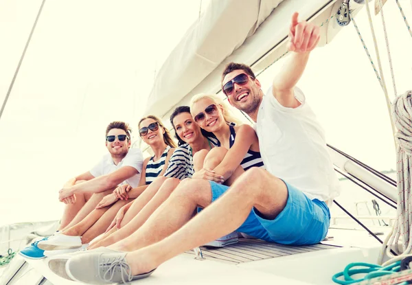 Amici sorridenti seduti sul ponte dello yacht — Foto Stock