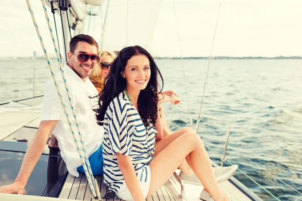 Smiling friends sitting on yacht deck — Stock Photo, Image