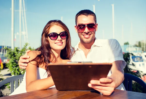 Sonriente pareja con menú en la cafetería — Foto de Stock