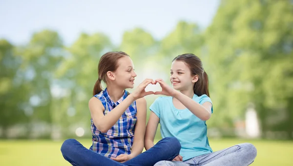 Niñas felices mostrando la forma del corazón signo de mano —  Fotos de Stock