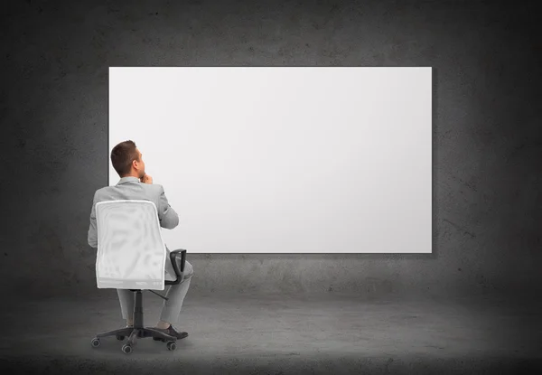 Businessman in office chair over white board — Stock Photo, Image