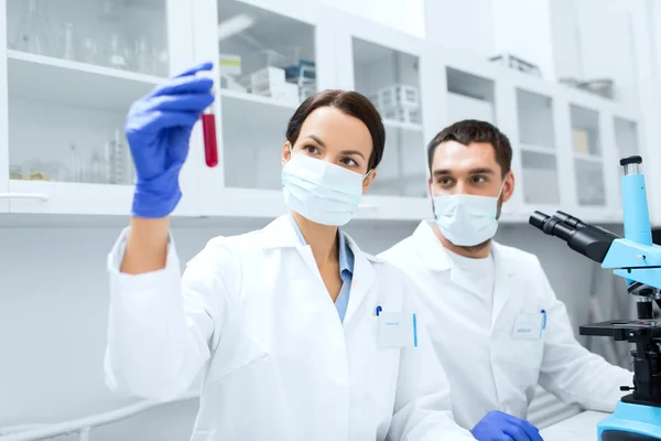 Jóvenes científicos haciendo pruebas o investigaciones en laboratorio —  Fotos de Stock