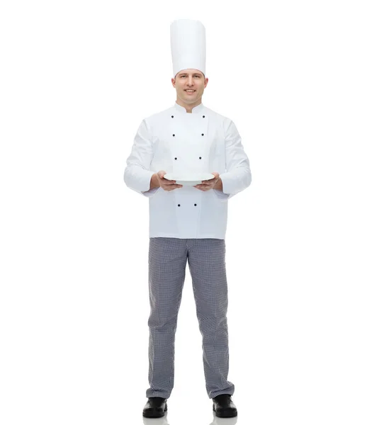 Happy male chef cook showing empty plate — Stock Photo, Image