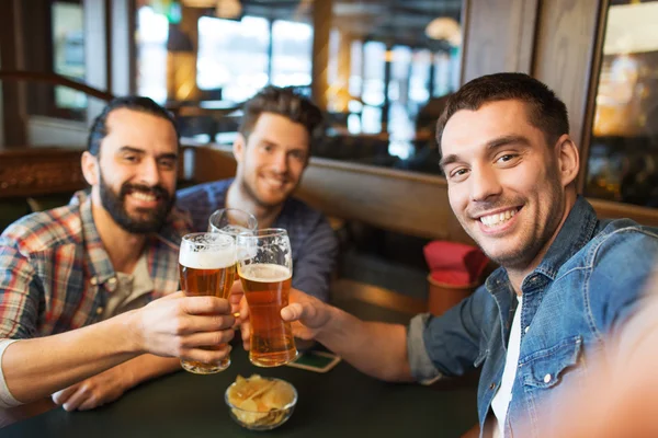 Friends taking selfie and drinking beer at bar — Stock Photo, Image