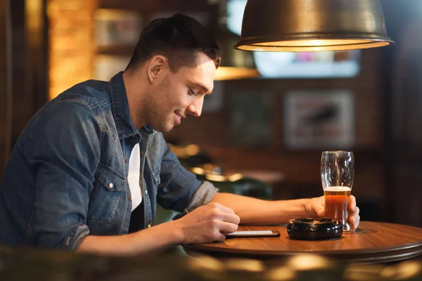 Homme avec smartphone et bière textos au bar — Photo