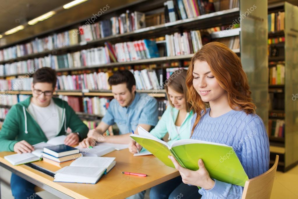 Happy students reading books in library Stock Photo by ©Syda