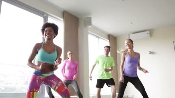 Grupo de pessoas sorrindo dançando no ginásio ou estúdio — Vídeo de Stock