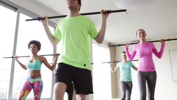 Grupo de personas haciendo ejercicio con bares en el gimnasio — Vídeos de Stock