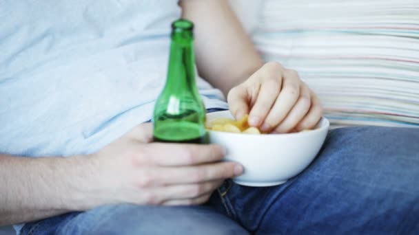 Κοντινό πλάνο του ανθρώπου, τρώγοντας τσιπς και πίνοντας μπύρα — Αρχείο Βίντεο