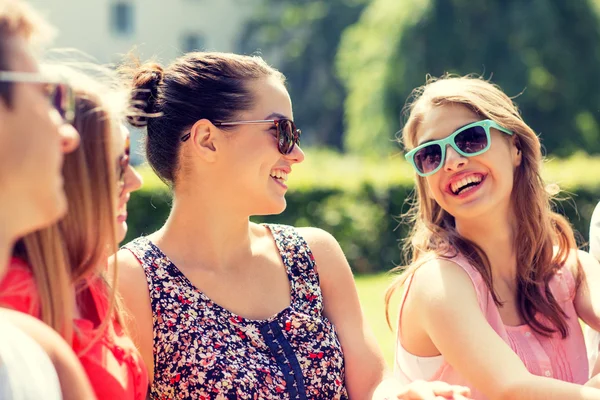 Groupe d'amis souriants à l'extérieur assis dans le parc — Photo