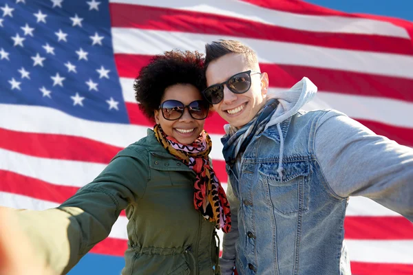 Casal feliz tomando selfie sobre a bandeira americana — Fotografia de Stock