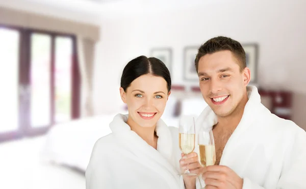 Happy couple in bathrobes over spa hotel room — Stock Photo, Image
