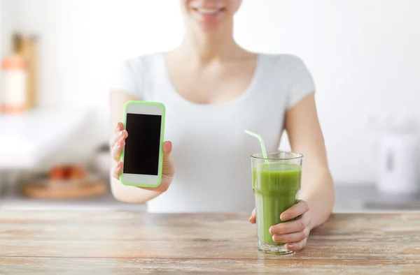 Close up of woman with smartphone and green juice — Stock Photo, Image