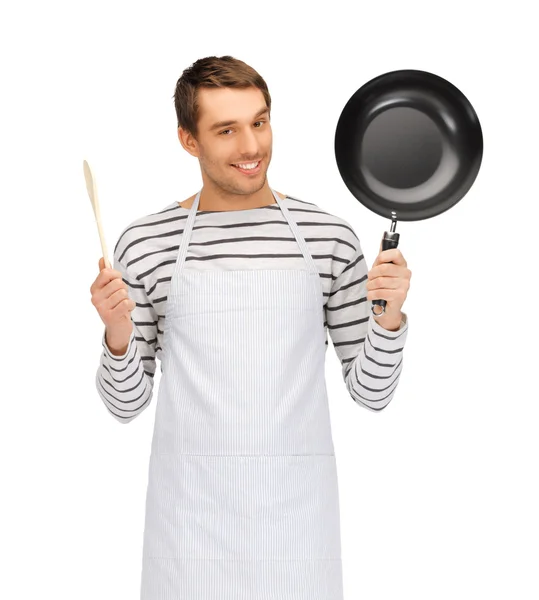 Happy man or cook in apron with pan and spoon — Stock Photo, Image