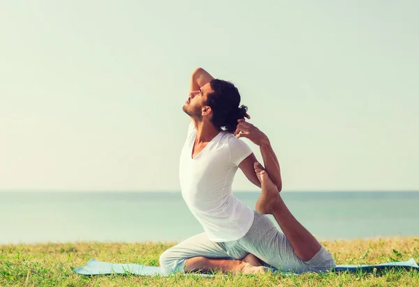 Yoga yaparak gülümseyen adam açık havada egzersiz — Stok fotoğraf