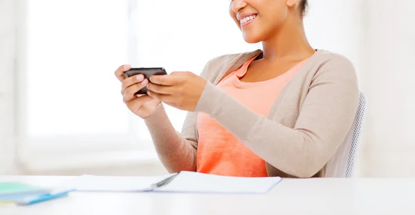 African woman with smartphone in office — Stock Photo, Image