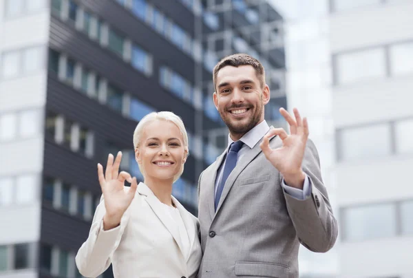 Hommes d'affaires souriants debout au-dessus de l'immeuble de bureaux — Photo