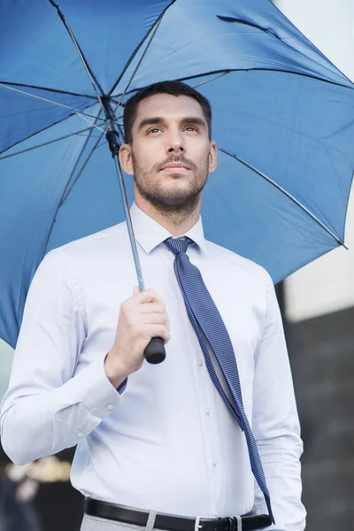 Giovane uomo d'affari serio con ombrello all'aperto — Foto Stock