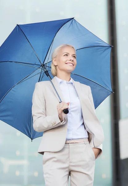 Junge lächelnde Geschäftsfrau mit Regenschirm im Freien — Stockfoto