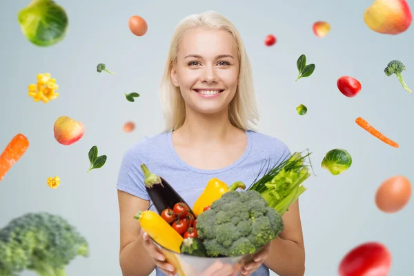 Lachende jonge vrouw met groenten — Stockfoto