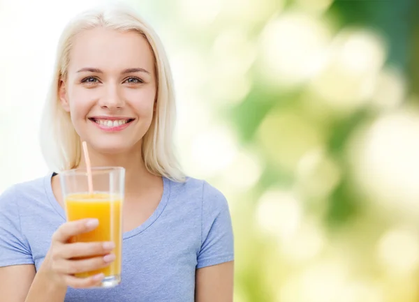 Mulher sorridente bebendo suco de laranja — Fotografia de Stock