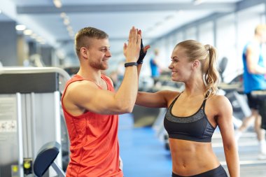 smiling man and woman doing high five in gym clipart