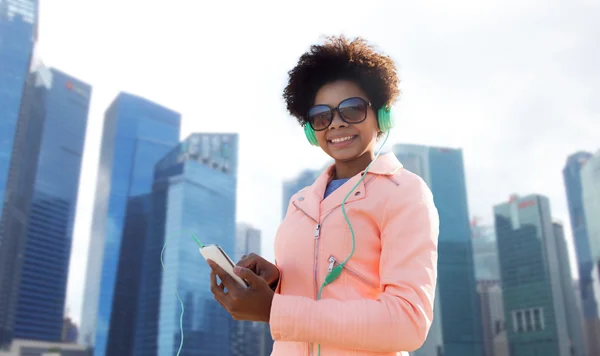 Happy young woman with smartphone and headphones — Stock Photo, Image