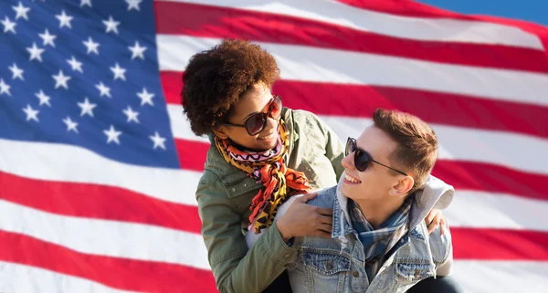 Счастливая многорасовая пара над американским флагом — стоковое фото