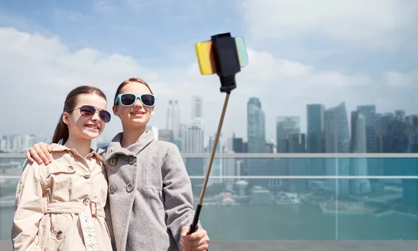 Ragazze con smartphone selfie bastone in singapore — Foto Stock