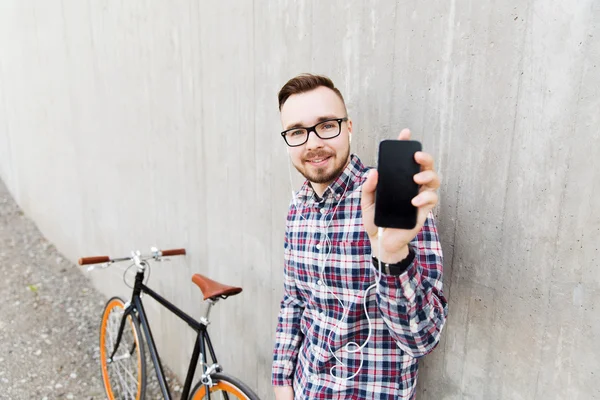 Homem hipster em fones de ouvido com smartphone e bicicleta — Fotografia de Stock