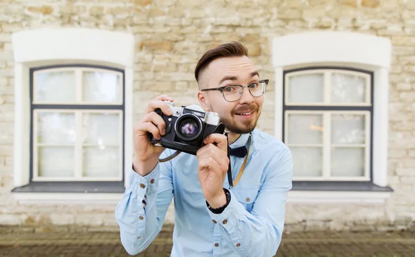 Feliz jovem hipster homem com câmera de filme na cidade — Fotografia de Stock