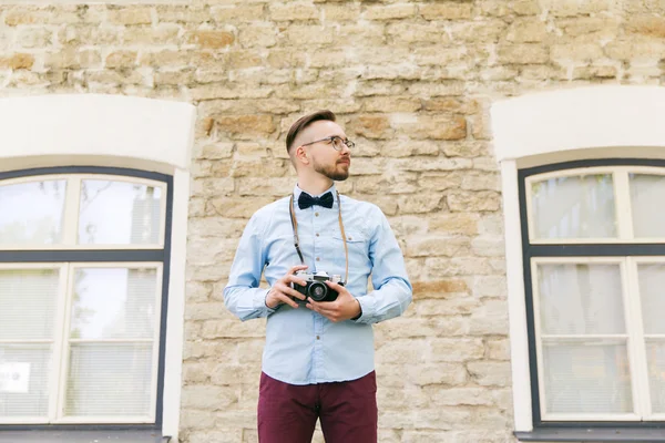 Joven hipster hombre con cámara de cine en la ciudad —  Fotos de Stock