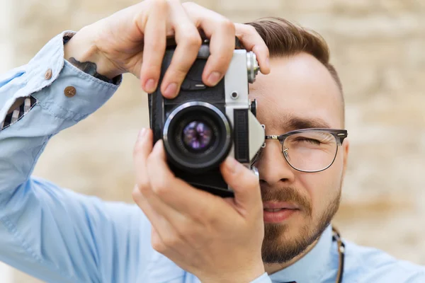 Hipster młody człowiek z kamerą w mieście — Zdjęcie stockowe