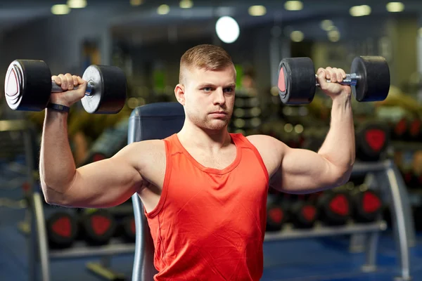 Içinde jimnastik salonu kas esneme dumbbells ile genç adam — Stok fotoğraf