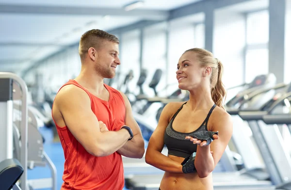 smiling man and woman talking in gym