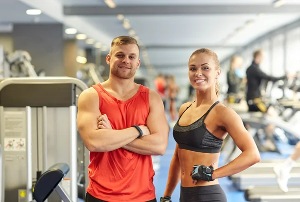 Homme et femme souriants dans la salle de gym — Photo