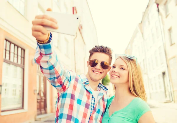 Coppia sorridente con smartphone in città — Foto Stock