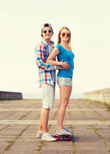 Sonriente pareja con monopatín al aire libre —  Fotos de Stock