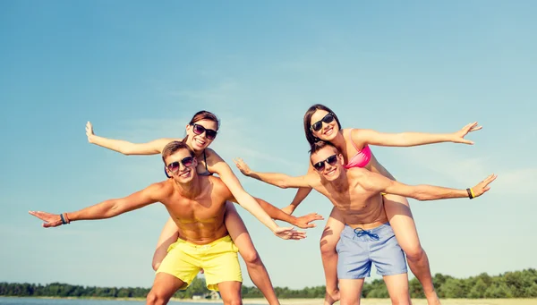 Uśmiechnięty znajomych zabawy na plaży latem — Zdjęcie stockowe