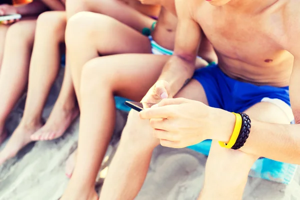 Close up of friends with smartphones on beach — Stock Photo, Image