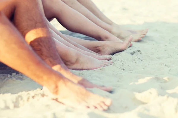 Close up van vrienden zittend op zomer strand — Stockfoto