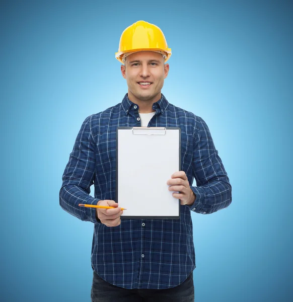 Sorridente construtor masculino no capacete com prancheta — Fotografia de Stock