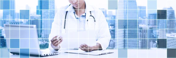 Doctor femenino con la PC portátil mirando el papel —  Fotos de Stock