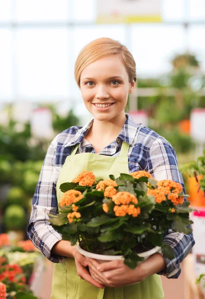 Happy woman holding flowers in greenhouse — Stock Photo, Image