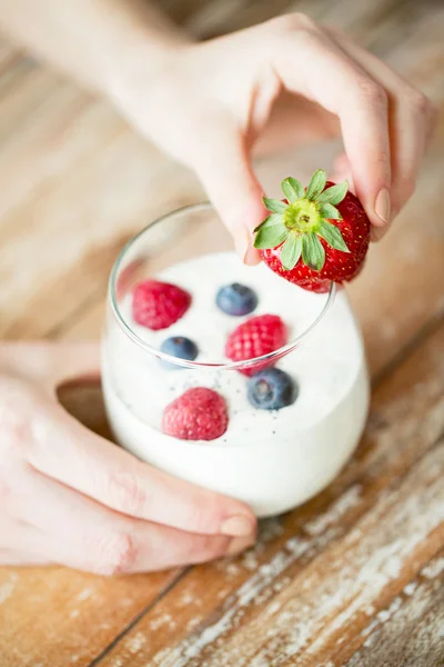 Primer plano de las manos de la mujer con yogur y bayas —  Fotos de Stock