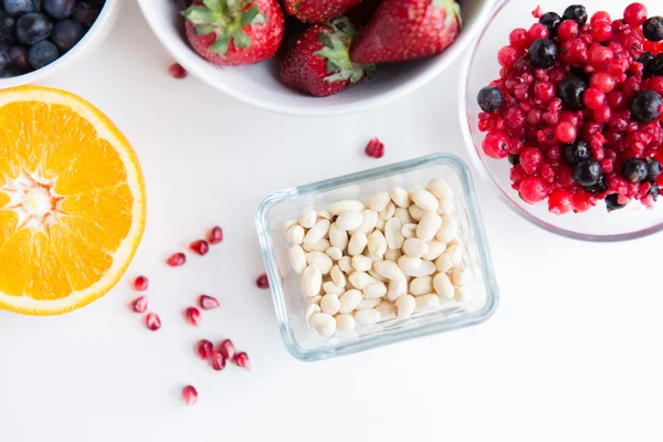 Close-up de frutas e bagas em tigelas na mesa — Fotografia de Stock