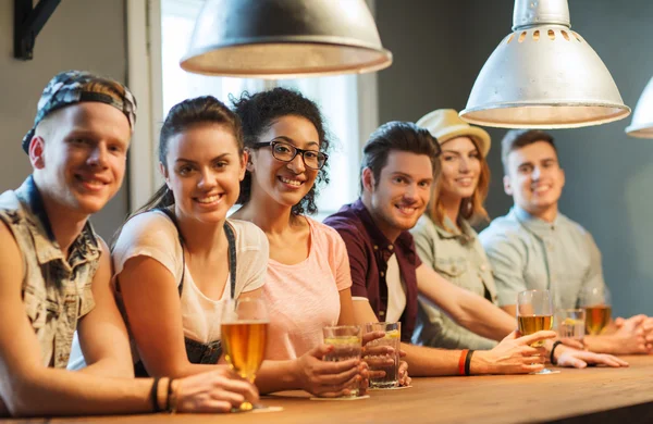Amigos felices bebiendo cerveza y cócteles en el bar — Foto de Stock