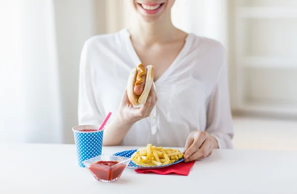 Close up de mulher comer cachorro-quente e batatas fritas — Fotografia de Stock