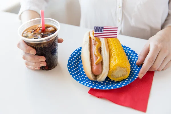 Close up van vrouw eten hotdog met coca cola — Stockfoto