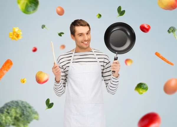 Homem feliz ou cozinhe em avental com panela e colher — Fotografia de Stock